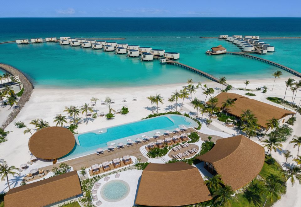 Vista aérea do Centara Grand Lagoon Maldives com praia, piscina e water villas