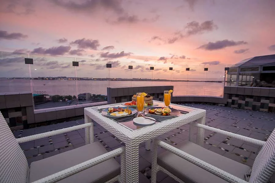 Mesas do restaurante Cloud no terraço do Samann Grand, com vista sobre o mar em Malé